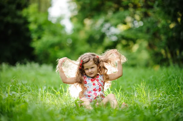 Pequena menina bonita no jardim verde — Fotografia de Stock