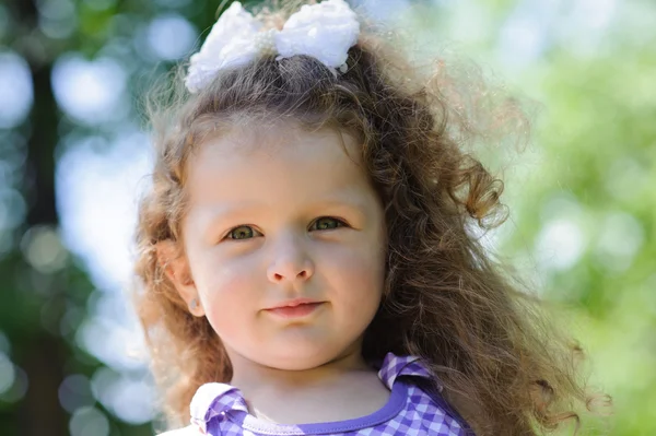Маленька красива дівчинка в зеленому саду — стокове фото