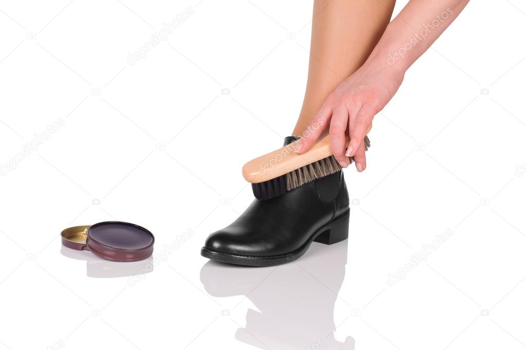 Hand with brush cleaning shoes