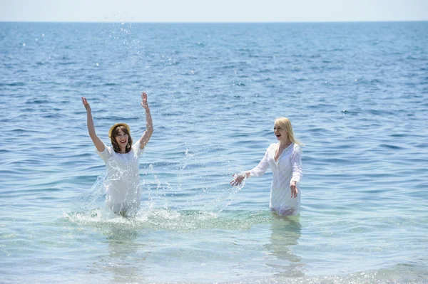 Gelukkig meisjes spatten in de zee — Stockfoto