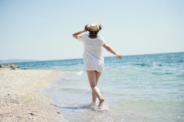 Счастливая девушка бежит по морскому пляжу — стоковое фото