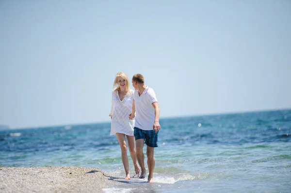 Счастливая пара бежит по морскому пляжу — стоковое фото