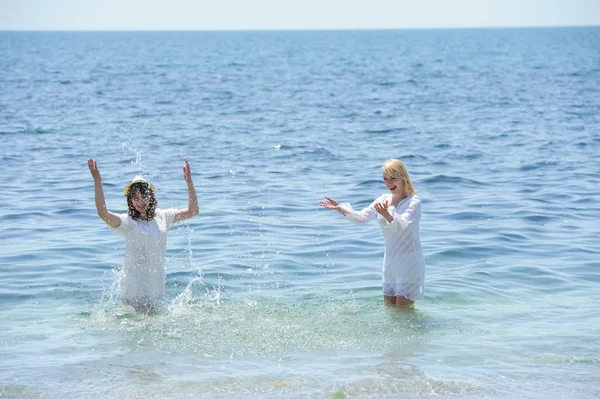 Gelukkig meisjes spatten in de zee — Stockfoto