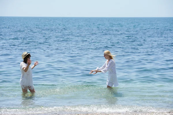 Happy girls splashing in the sea — Stock Photo, Image