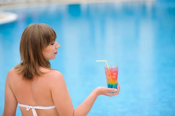 Meisje met cocktail in de pooll zwemmen — Stockfoto