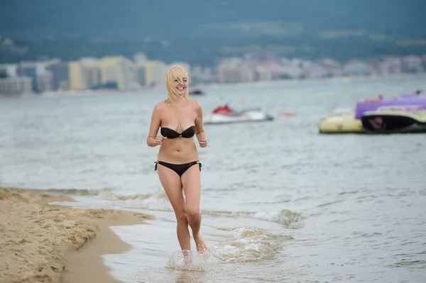 Женщина бежит по морскому пляжу — стоковое фото