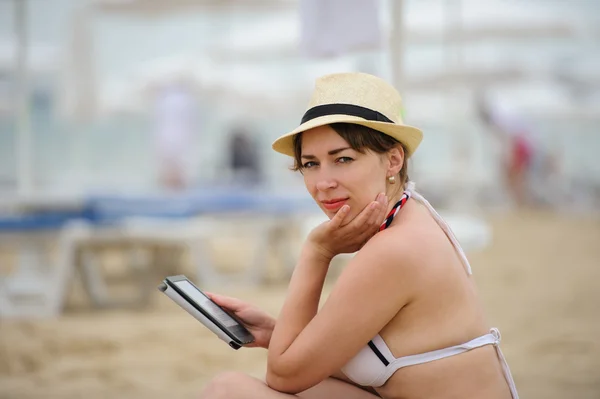 Donna che legge tablet reader sulla spiaggia — Foto Stock