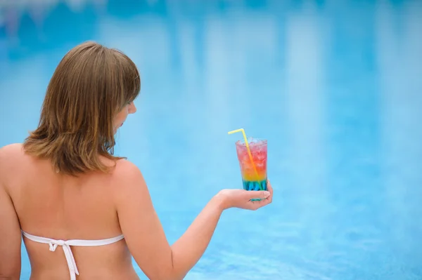 Meisje met cocktail in de pooll zwemmen — Stockfoto