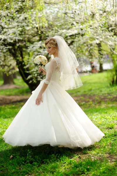 Mooie bruid met boeket van bloemen buiten — Stockfoto