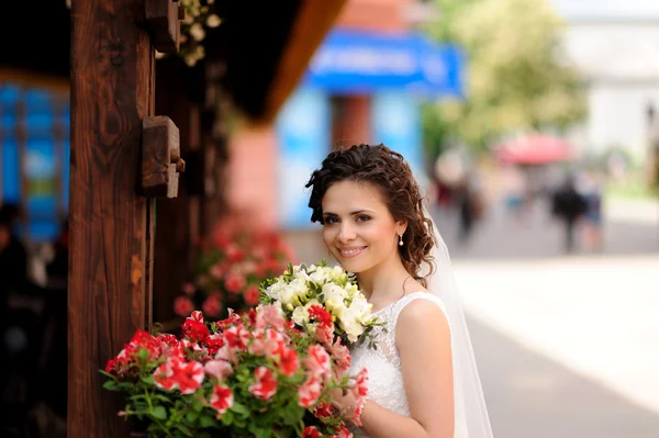 Schöne Braut mit Blumenstrauß im Freien — Stockfoto