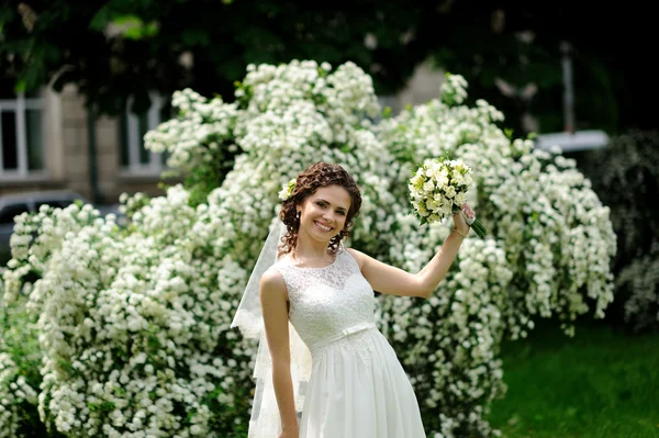 Mooie bruid met boeket van bloemen buiten — Stockfoto