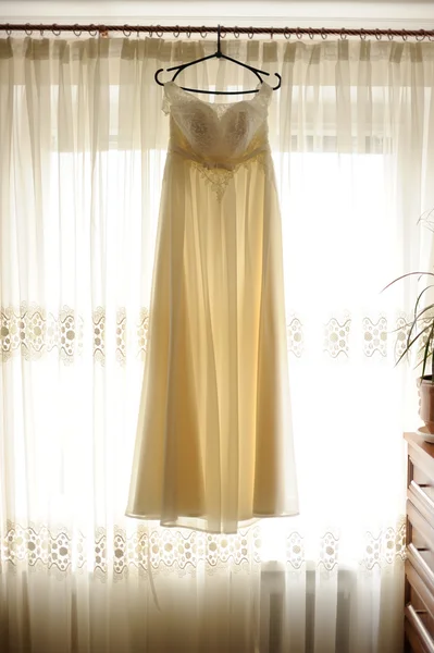 Wedding dress at home, hanging on the window — Stock Photo, Image