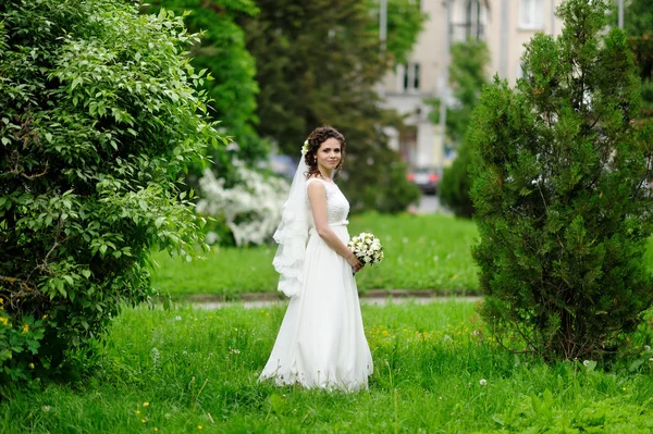 Hermosa novia con ramo de flores al aire libre — Foto de Stock