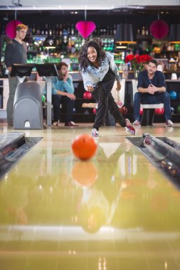 kadın bowling oynuyor ve bir topu atar