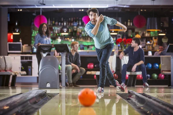 Jovem está a jogar bowling com os amigos — Fotografia de Stock
