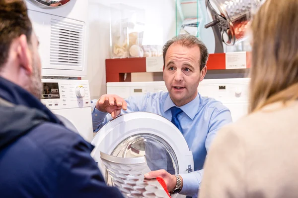 Vendedor explicando produto para casal no hipermercado — Fotografia de Stock