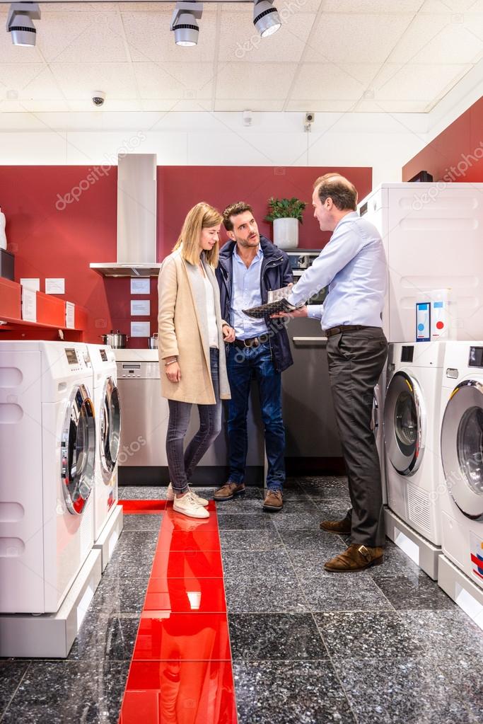 Salesman Explaining Product Quality At Appliances Store Stock Photo by ©Corepics 103536356