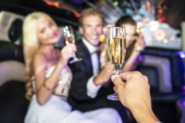 Rich people drinking champagne in a limousine clipart