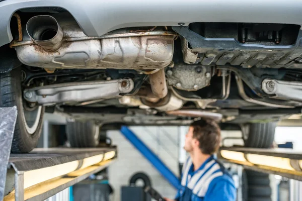 Mecánico masculino trabajando bajo el coche — Foto de Stock