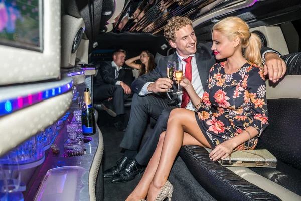 Paar champagne fluiten in limousine roosteren — Stockfoto