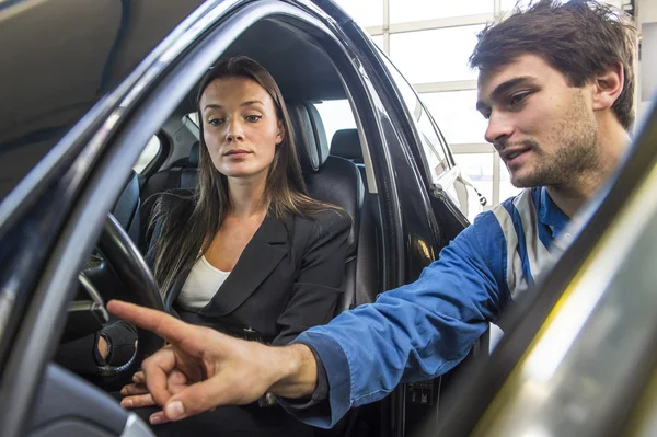 Mechanic explaining and instructing a customer — Stock Photo, Image