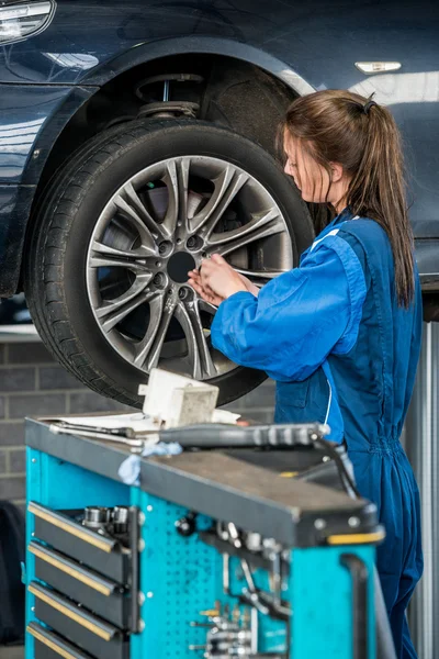 Kvinnlig mekaniker byta hjul på bilen — Stockfoto