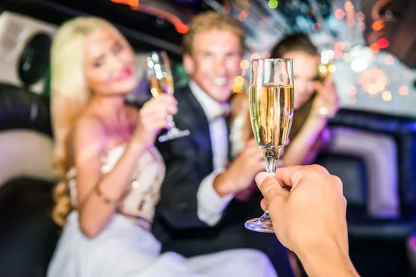 Amis avec flûte à champagne en limousine — Photo