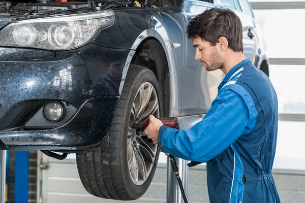 Männlicher Mechaniker repariert Reifen — Stockfoto