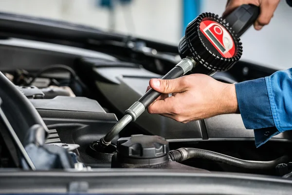 Mannelijke mechanic handen vullen van olie in auto — Stockfoto