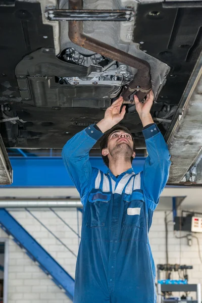 Mechanic examining exhaust system — Stock Photo, Image