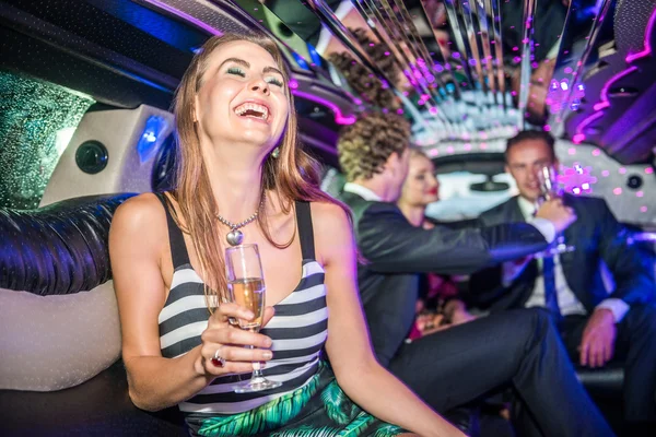 Kvinna med champagneglas i limousine — Stockfoto