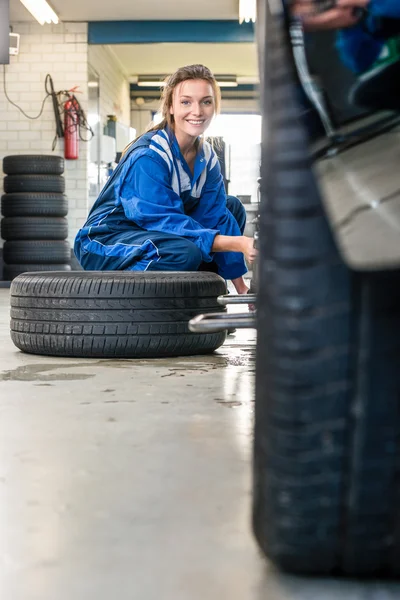 Kobiece mechanik zmieniających opony samochodu — Zdjęcie stockowe