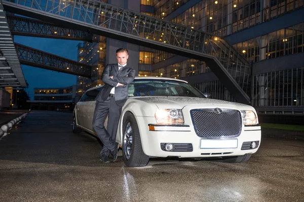 Elegant man standing by limousine — Stock Photo, Image