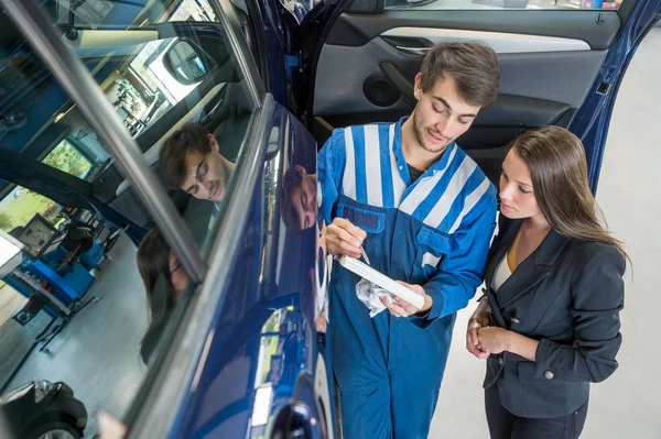 Mechanic with female customer — Stock Photo, Image