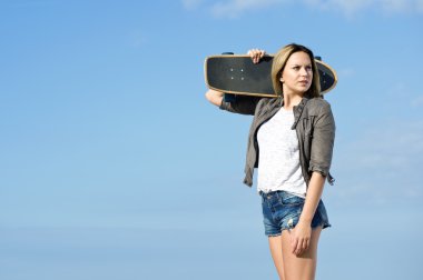 Pretty girl carrying skateboard clipart