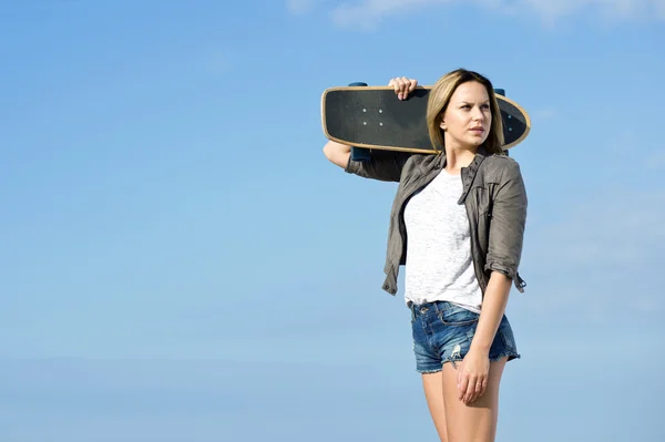 Bella ragazza che trasporta skateboard — Foto Stock