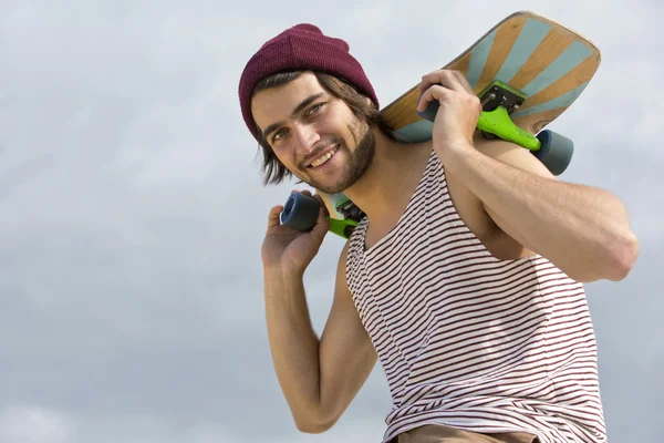 Skateboarder carrying his skateboard — Stock Photo, Image