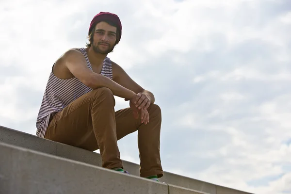 Skateboarder sitting on concrete steps — Stock Photo, Image