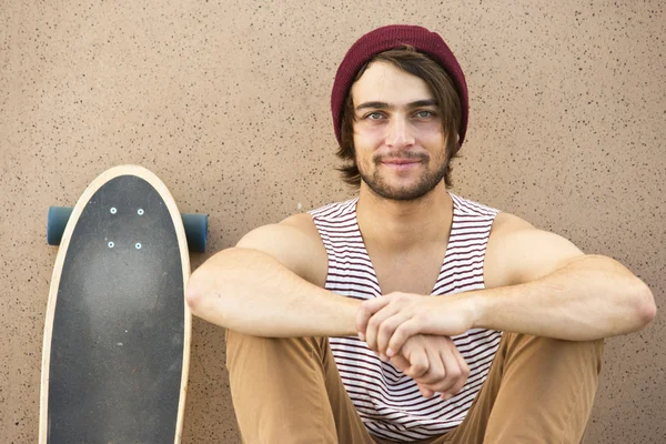 Skateboarder zitten tegen muur — Stockfoto