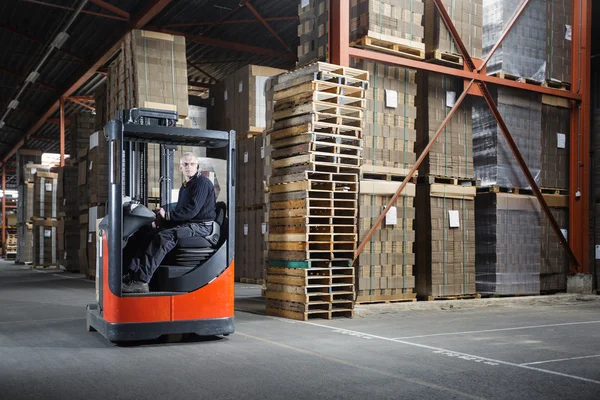 Uomo alla guida di raggiungere camion in un magazzino — Foto Stock