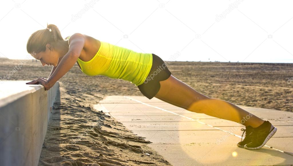 Woman doing press ups at beach