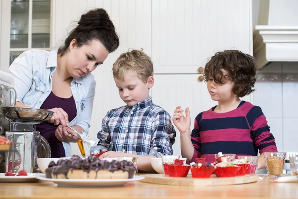 Mother and children preparing cupcake Royalty Free Stock Images
