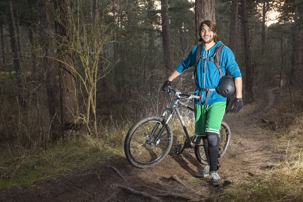 Ung man med hans atb i skogen — Stockfoto