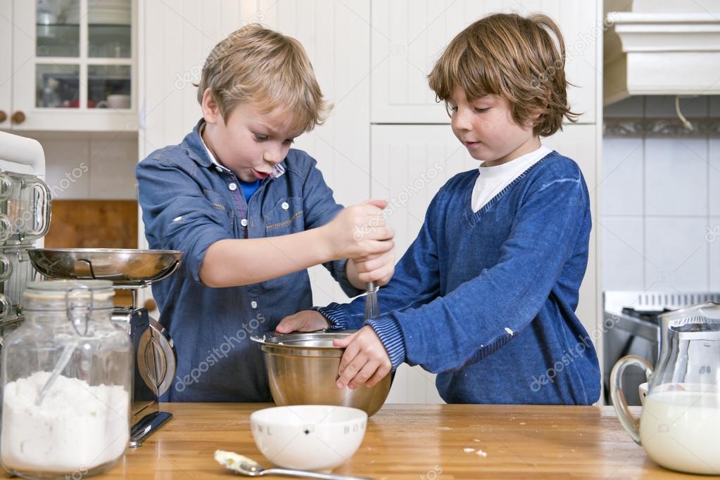 Boys mixing dough in a bowl using a whisk