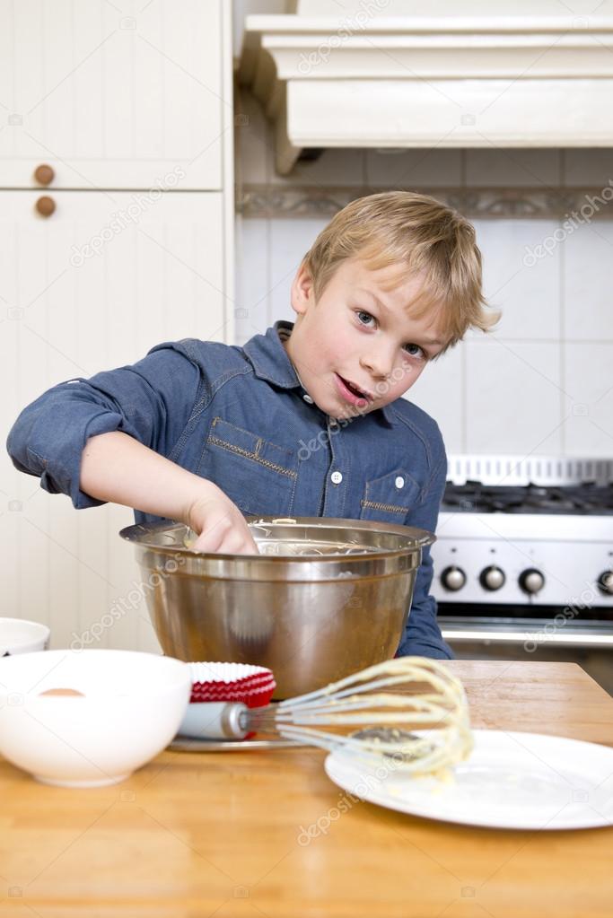 Young boy baking pies in a kitchen