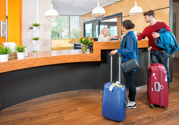 Giovani viaggiatori al check-in in hotel — Foto Stock