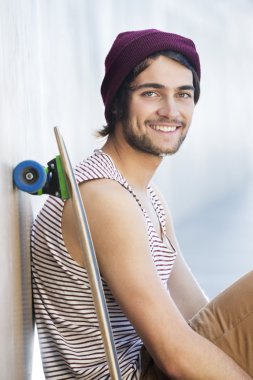 Kaykay ile oturan mutlu adam