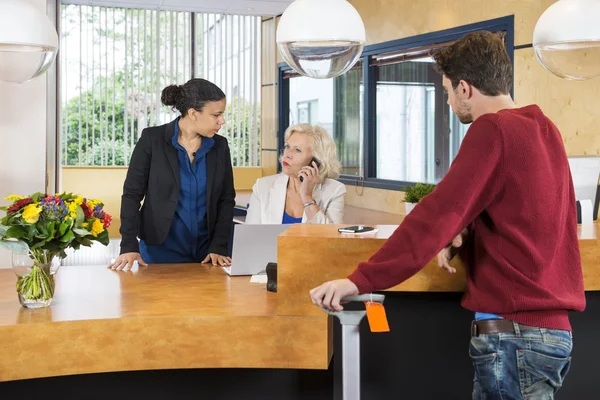 Man op zoek naar receptionisten In Hotel — Stockfoto