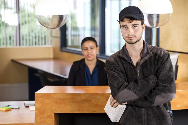 Delivery Man Standing At Office Reception — Stock Photo, Image