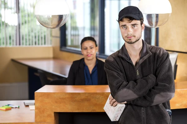 Zusteller steht am Empfang im Büro — Stockfoto